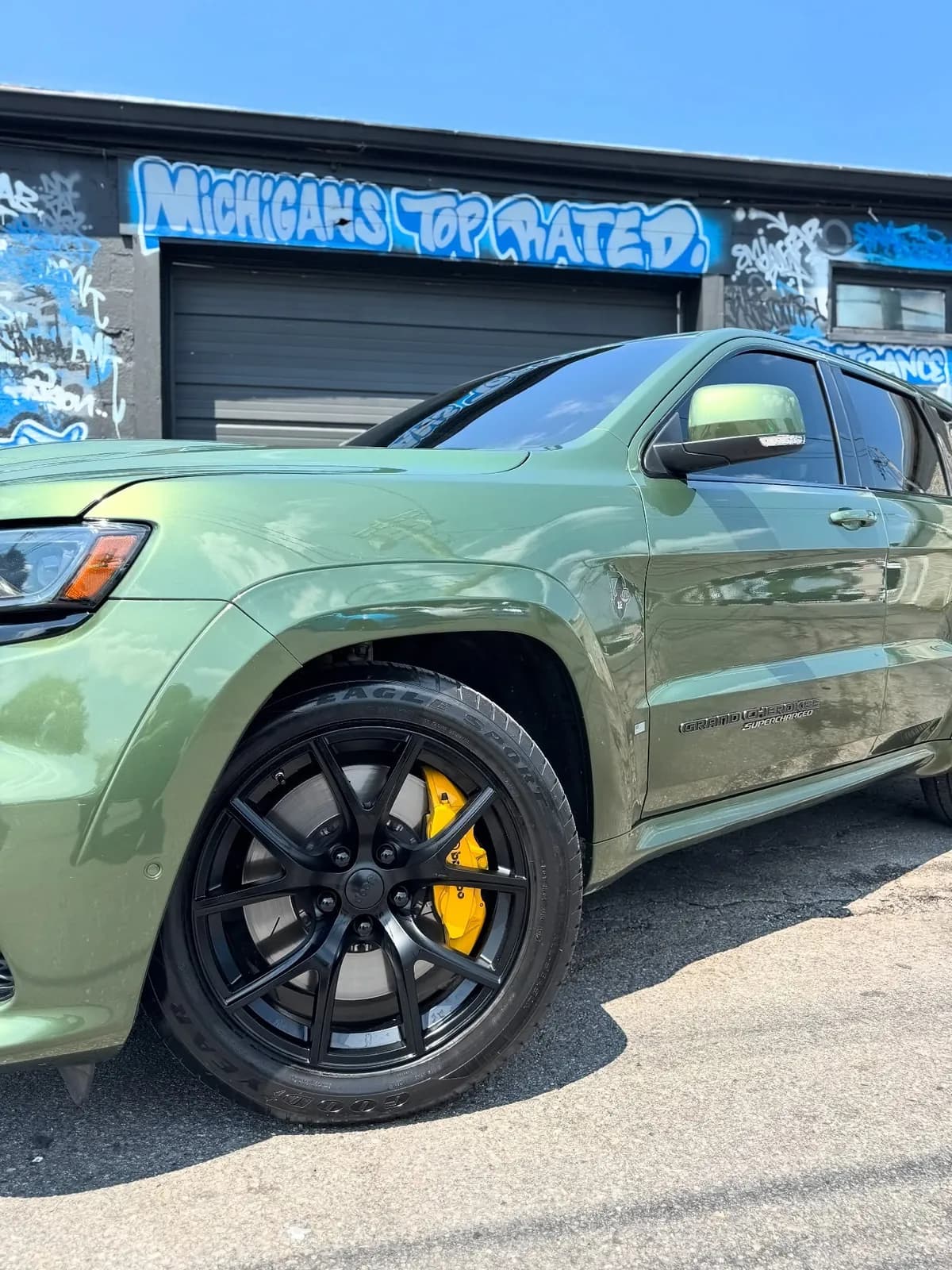 Green Jeep Trackhawk with yellow painted brake calipers outside the Buff X Customization shop