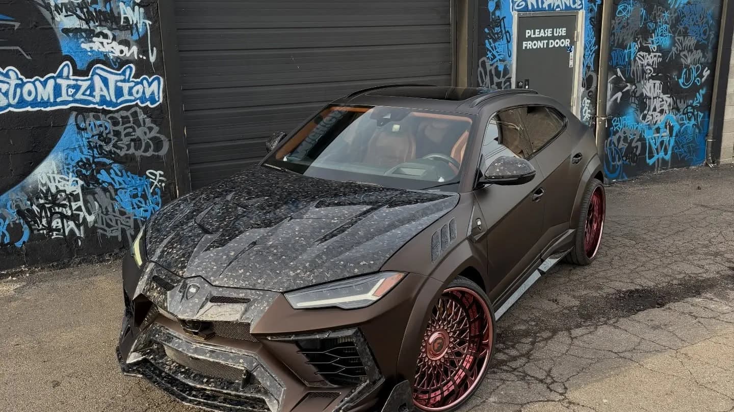 Lamborghini Urus with a forged carbon hood and red forged wheels, a custom build by Buff X Customization in Dearborn Heights
