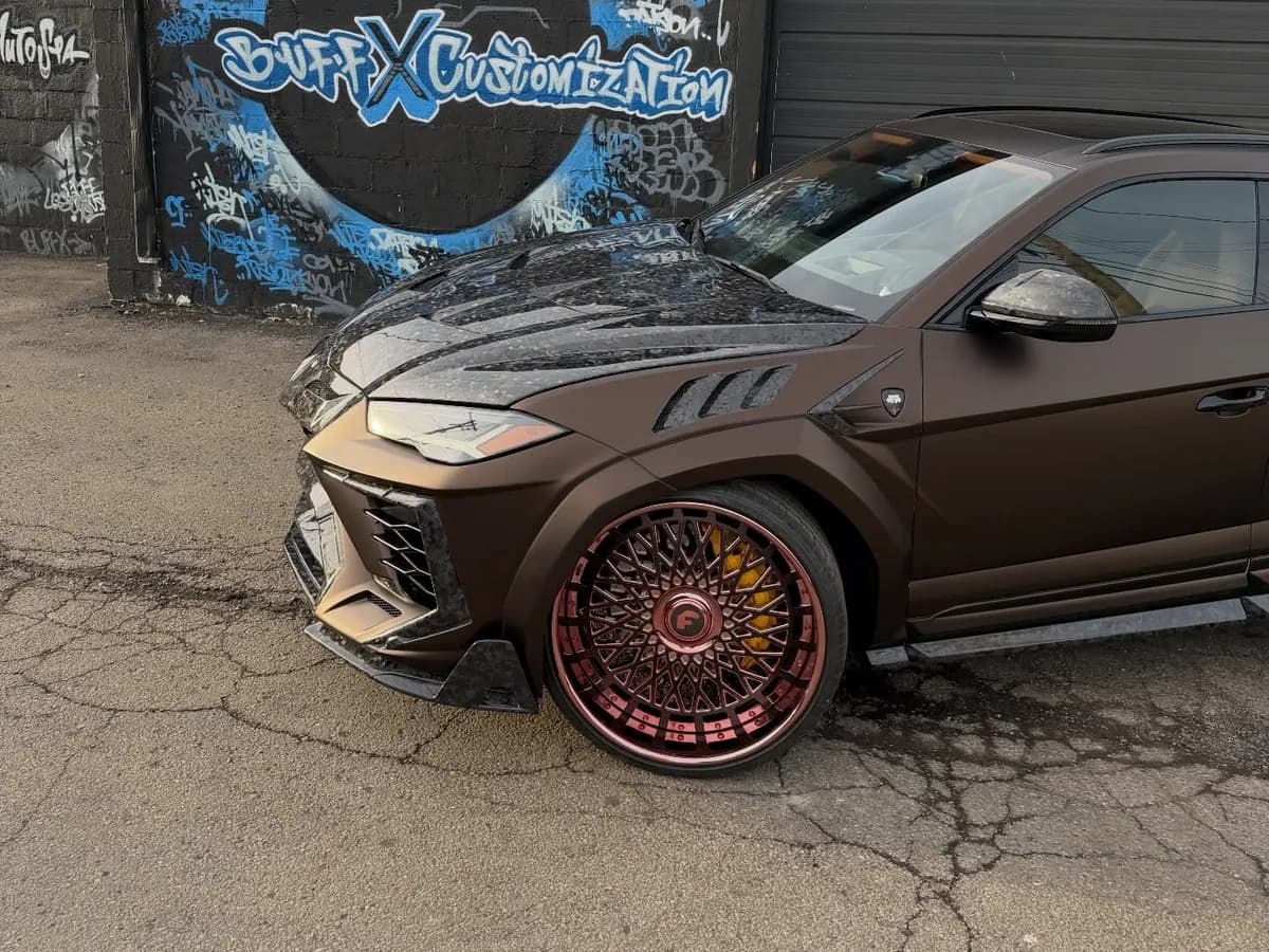 Side view of a custom Lamborghini Urus build on red forged wheels at Buff X Customization