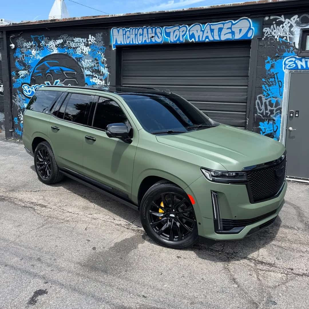 Matte green Cadillac Escalade with a full vinyl wrap